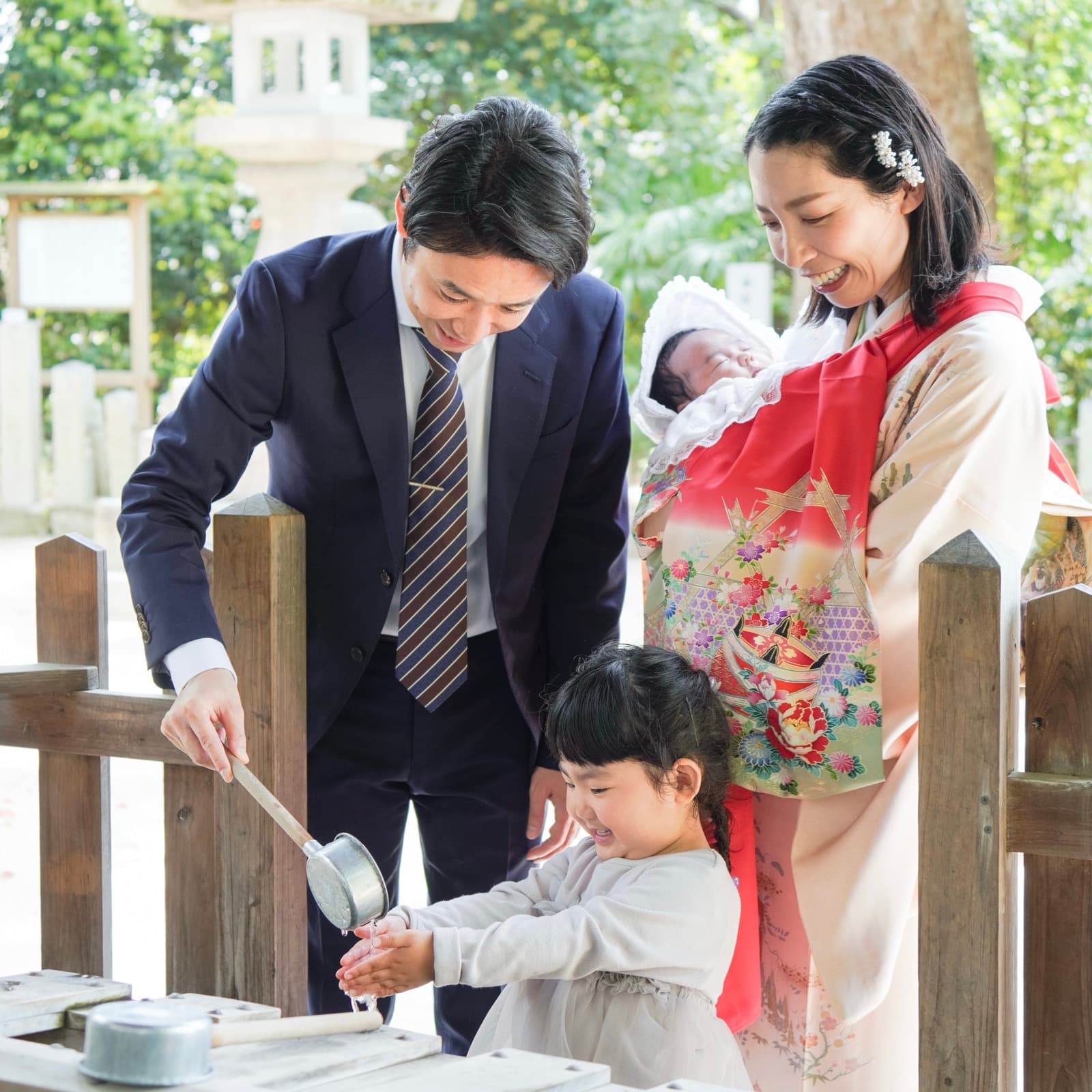 神社で赤ちゃんを抱くご家族